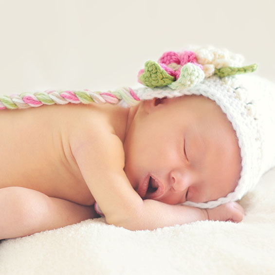 Nyfødt baby sover med hue